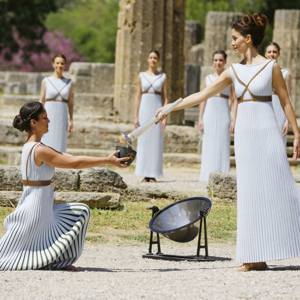 Actress Katerina Lehou, right, as high priestess, lights a pot with the Olympic Flame, during the final dress rehearsal of the lighting of the Olympic flame at Ancient Olympia, in western Greece on Wednesday, April 20, 2016. The flame will be transported by torch relay to the Brazilian city of Rio de Janeiro, which will host the Aug. 5-21, 2016 Olympics. (AP Photo/Thanassis Stavrakis)